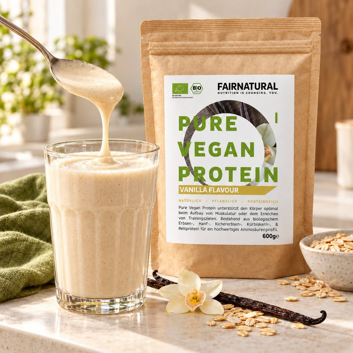 Cremiger Vanille-Proteinshake neben dem Fairnatural 600-g-Beutel